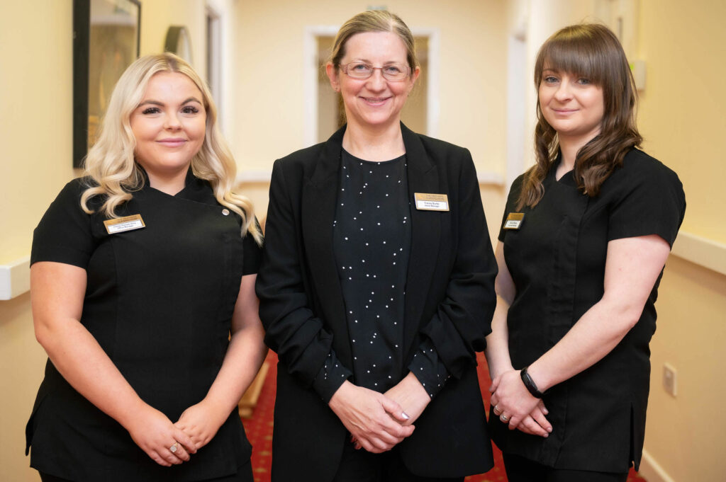 3 members of staff smiling.