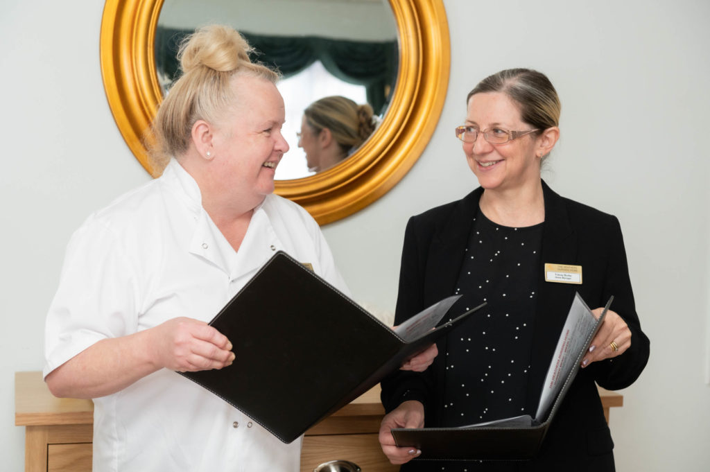 Two members of staff going through black books together.